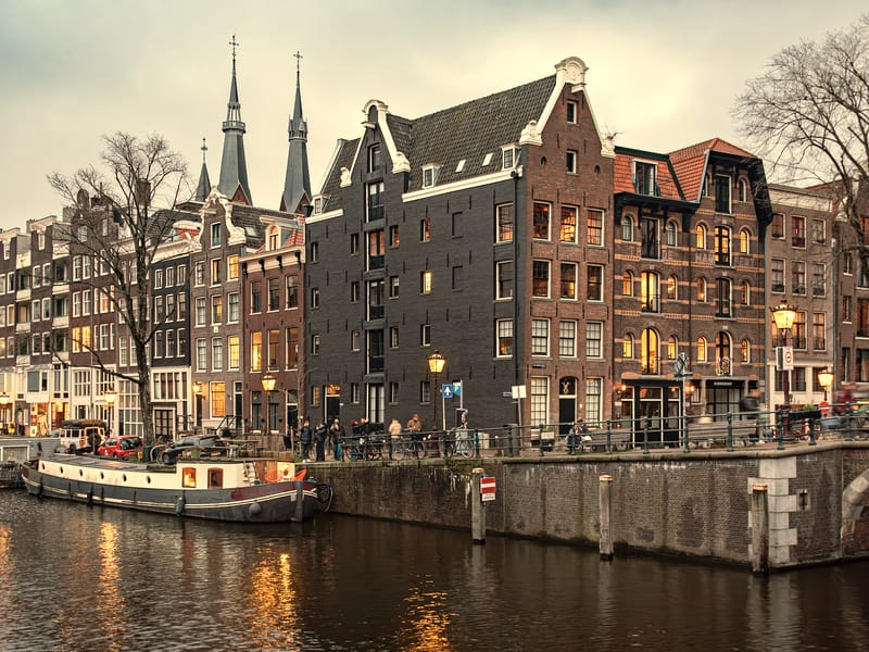 Canal houses glowing at dusk along the water